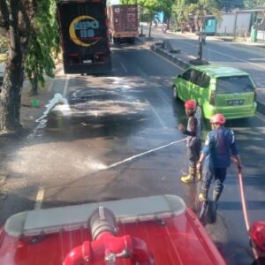 Tumpahan Solar Bikin Jalan Poros Maros Licin, Petugas Damkarmat Lakukan Penyiraman